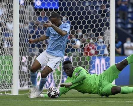 The Chelsea goalkeeper Édouard Mendy dives at the feet of the Manchester City forward Raheem Sterling to claim the ball during the 2021 Champions League final in Porto