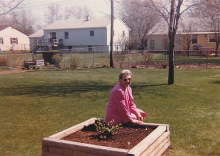 woman sitting on edge of planter box outside and smiling