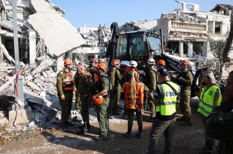 Rescue personnel work at an impact site following missile attack by Iran on Rishon LeZion, near Tel Aviv.