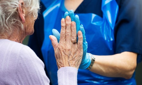 Older woman and carer touch hands