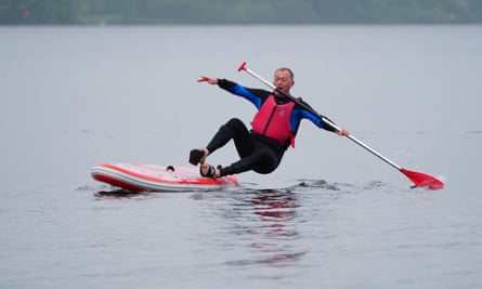 Lib Dem MP Tim Farron paddleboards on Lake Windermere, campaigning on water quality during the general election 2024.