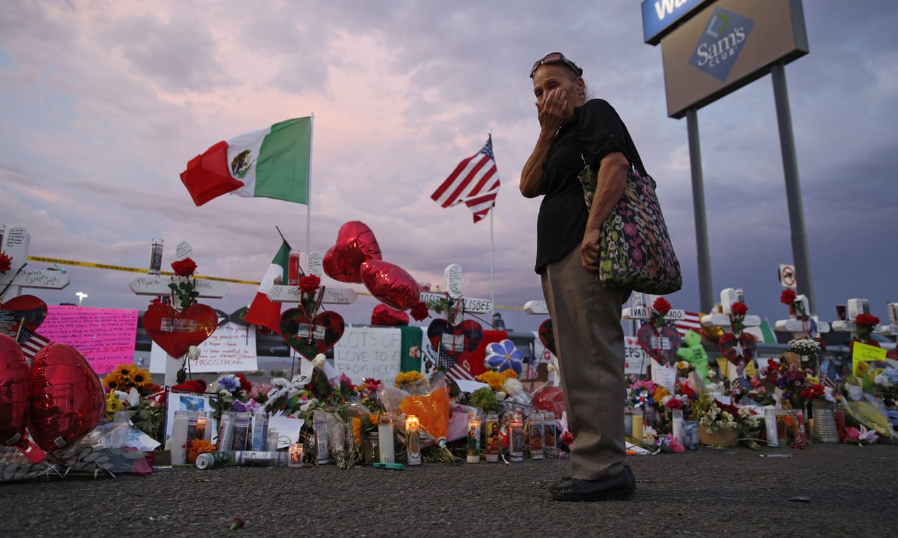 Catalina Saenz wipes tears from her face as she visits a makeshift memorial near the scene of the El Paso mass shooting