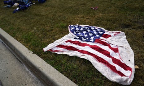 Empty chairs and an American flag blanket lie on the ground.