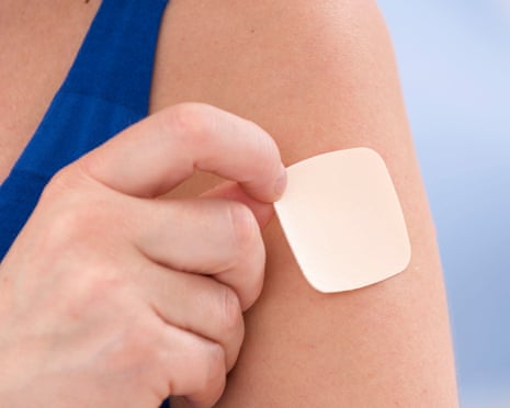 a woman puts a patch on her arm