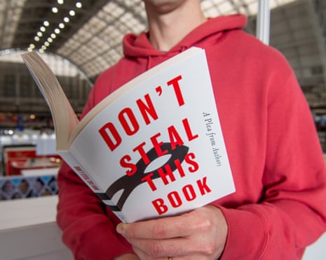 A man in a red hoodie holding the book
