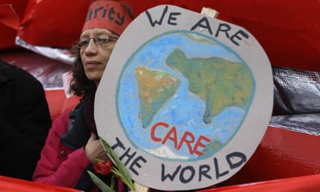 A climate activist holds up a banner showing a picture of the globe