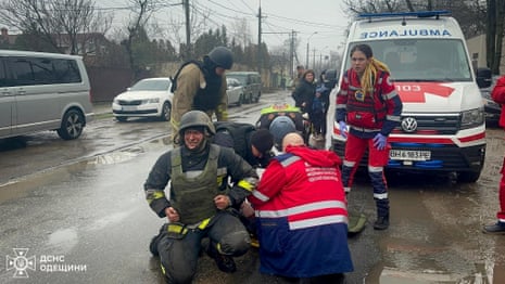 Paramedics help injured rescuers at the site of a Russian missile strike in Odesa, 15 March 2024.
