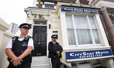 Police stand guard outside the City Stay hotel in east London where the Russian suspects are said to have stayed.