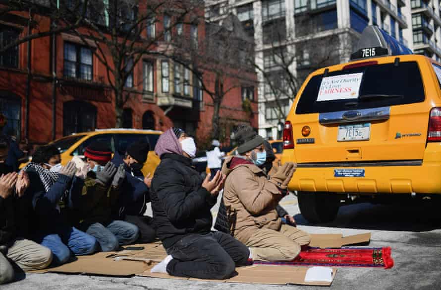 Yellow cab taxi drivers pray before joining a rally in New York City on 10 February, 2021. New York City taxi cab drivers held a day of action calling for debt forgiveness for loss of income amid work shortage due to the coronavirus pandemic.