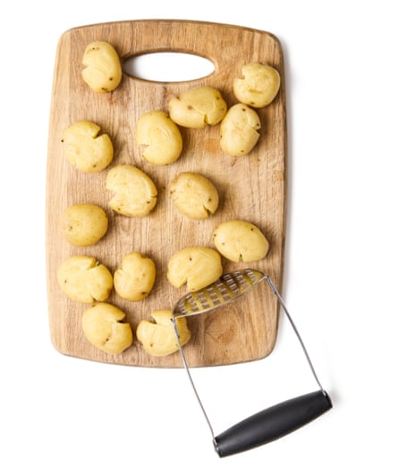 03a Felicity Cloake’s perfect roast new potatoes. Put the steamed potatoes on a board and lightly crush each one with a fork, spoon or potato masher, but only just so you hear the skins split, and not so hard that they break apart (though, if a few do, such is life).
