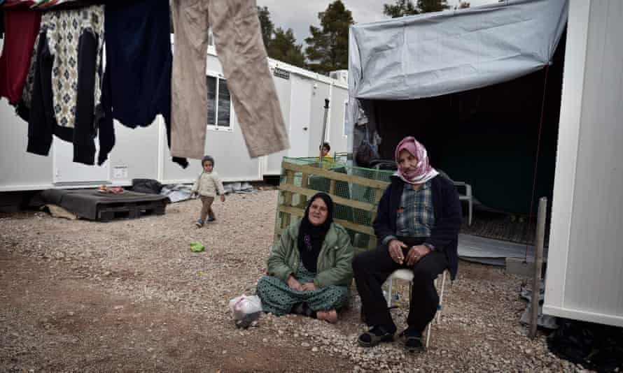 People sit near their container home in the Ritsona refugee camp, north of Athens, in December.