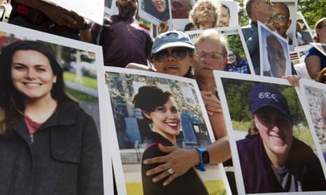 Victims’ families hold pictures of loved ones outside the transport department in Washington.