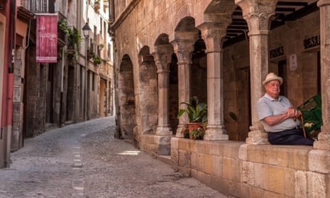 A man takes a nap under the arches in an old Spanish street