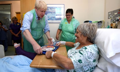 Boris Johnson serves food to Wenona Pappin, aged 70, during a visit to Torbay Hospital in Torquay,