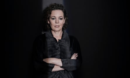 Olivia Colman in black top, arms folded, against black background, Oct 2021