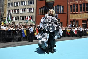 Miriana Conte poses wearing a dress the appears to be partly constructed from screwed up newspaper pages