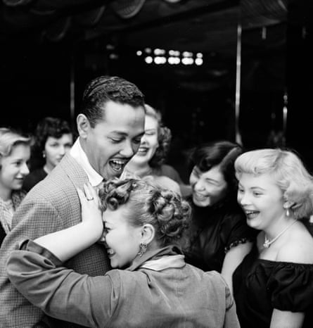 Singer Billy Eckstine gets a hug from an adoring fan after his show at Bop City as others look on. Photograph by Martha Holmes, Life, April 1950.