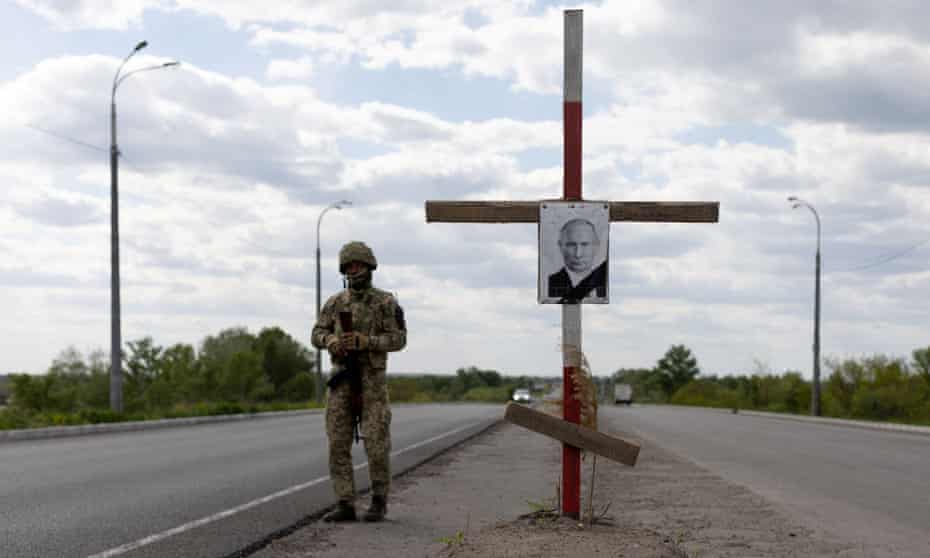 A portrait of Russian President Vladimir Putin in a cross depicting his tomb is seen at a checkpoint outside Dnipro.