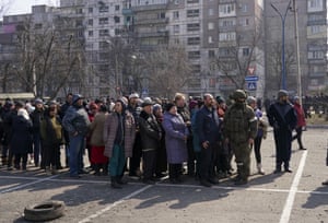 Civilians wait to receive aid parcels in the Ukrainian city of Mariupol.