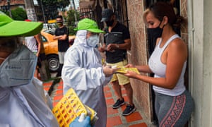 People receive bingo ballots in a game promoted by the city administration in Medellin, Colombia to encourage people to stay home during a new lockdown.