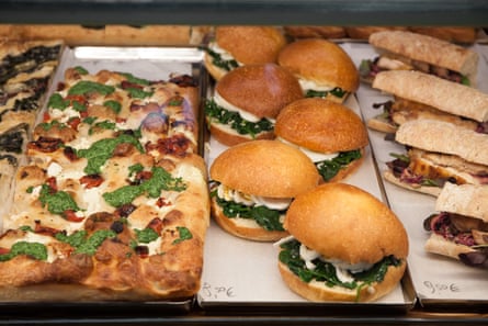 Pizza slices and sandwiches for sale in a deli