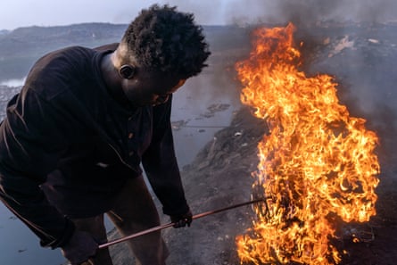 Simon Aniah burning scrap electrical cables by the Korle lagoon