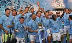 Captain Kyle Walker holds the Premier League trophy as Manchester City celebrate