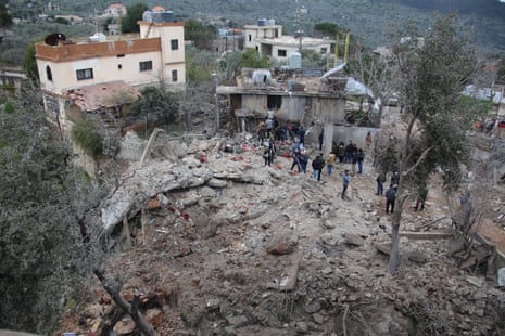 A group of people look at the damage of destroyed buildings after Israeli airstrikes on Hebbariyeh in southern Lebanon.