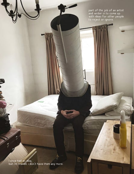 A man sits on a bed with a vey long and wide tube over his head which extends upwards.