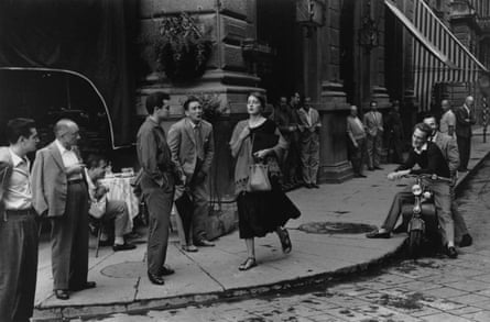A woman walks past a group of leering men on the streets of Florence, Italy