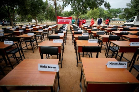 White name cards are displayed on rows of empty school desks