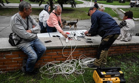 Residents charge their phones at a power plant in a street in Balakliia on 17 September.
