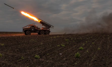 A rocket being fired in a field.