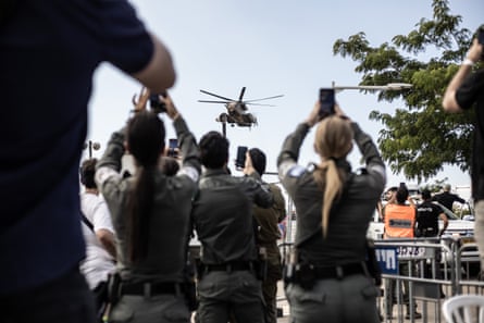 Crowd of people stand around filming a helicopter in Israel