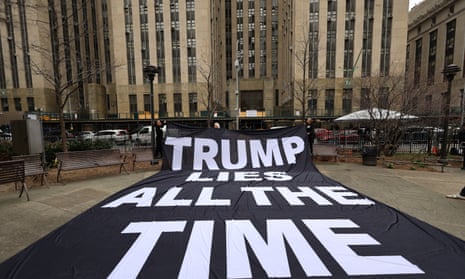 Anti-Trump protesters hold a banner in a park near the Manhattan criminal court, on Thursday.