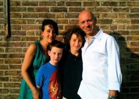 The family pose by a brick wall for a snapshot, close together