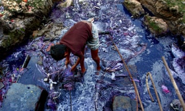 A boy salvages pieces of cloth from the liquid waste of the dyeing industries near Dhaka’s Turag river.