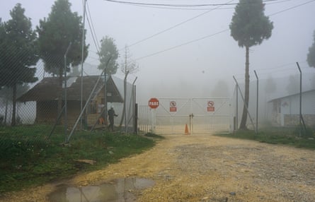 A gated entrance on a road, on a misty day