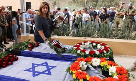 Woman places flowers on coffin