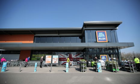 People follow physical distancing rules while they queue outside an Aldi store in Northwich on 27 March 27.