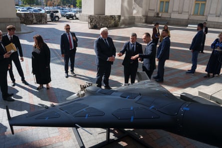 Officials gather around a Russian Shahed drone on display in Kyiv.
