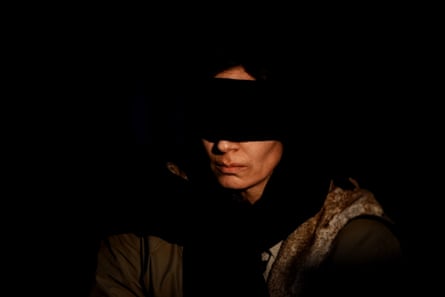 A woman with a black scarf across her eyes