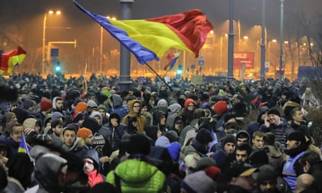 Crowds wave Romanian flags outside the government headquarters during a protest in Bucharest