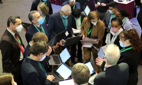 A group of people in laptops stand in a circle at Cop15 in Montreal, Canada.
