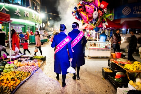 Twins wearing a ribbon advertising the Tropic of Cancer twin festival at Mojiang’s night market