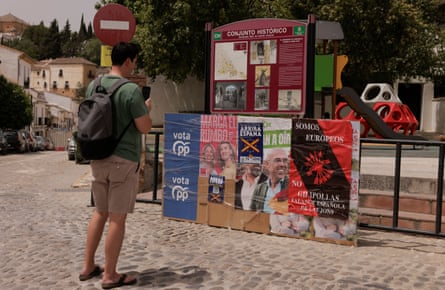 A tourist takes a picture of European election campaign posters
