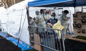 Medical workers don protective equipment at the beginning of their shift at the emergency field hospital.