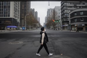 A woman walks on an empty road on 27 January when Wuhan was under strict lockdown.