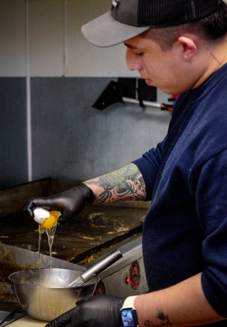 Man breaks an egg into a bowl as he prepares to make scrambled eggs at Cafe Urbano, N Elson Ave.