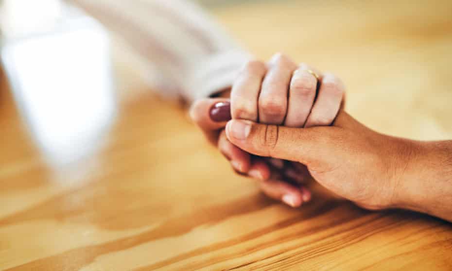 Cropped shot of a woman sitting with her friend at home and holding her hand in support.